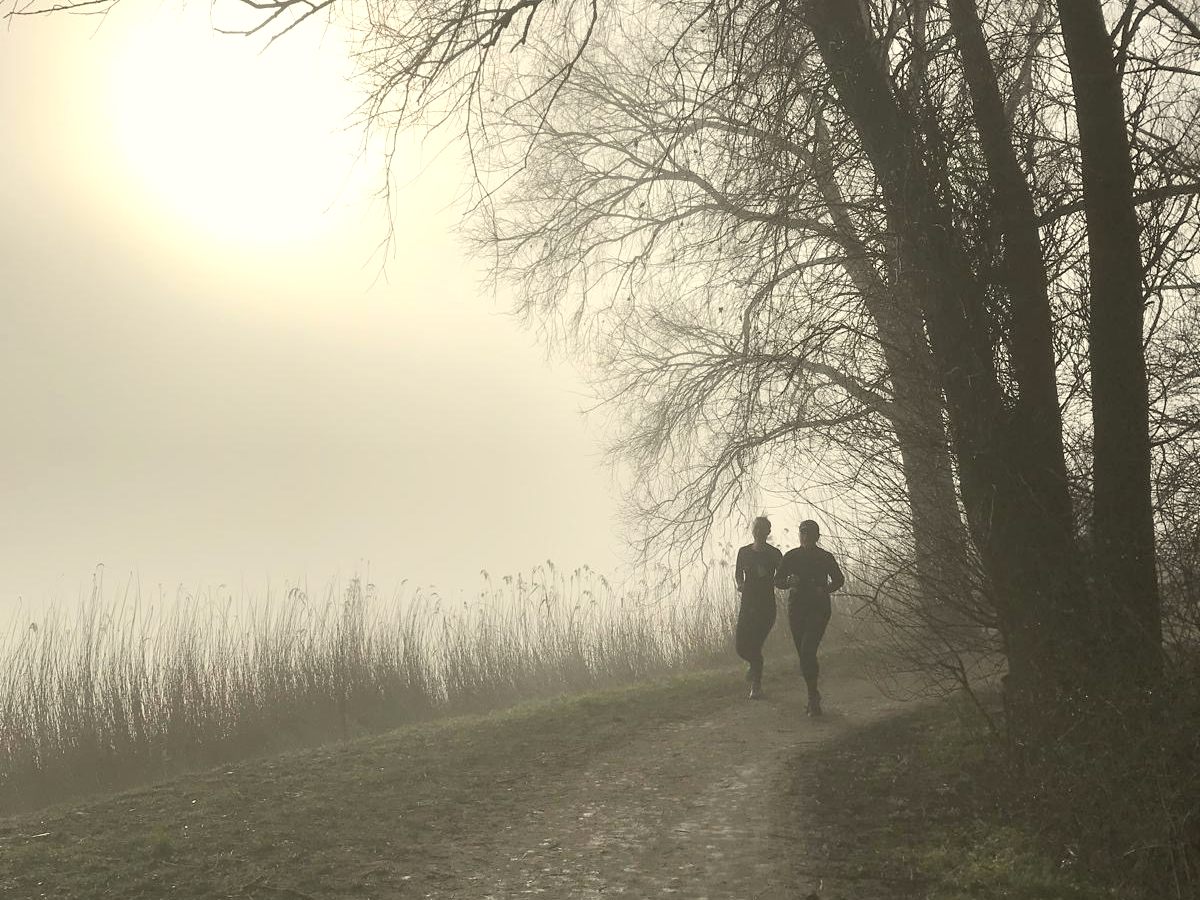 Twee hardlopers in de ochtendmist op het pad langs het Zomerdel in Geestmerambacht